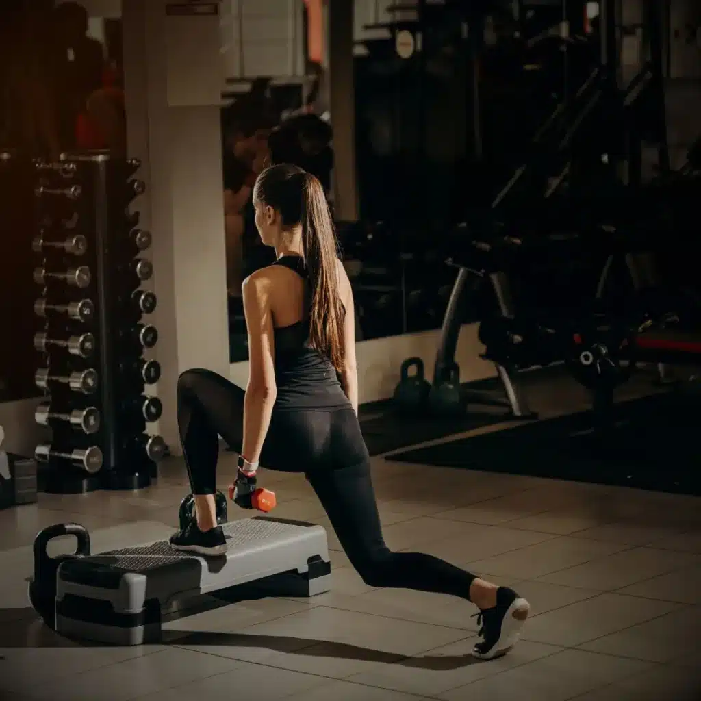 Mujer entrenando fuerza funcional con mancuernas en Legends Fitness Club, gimnasio en Torrejón de Ardoz